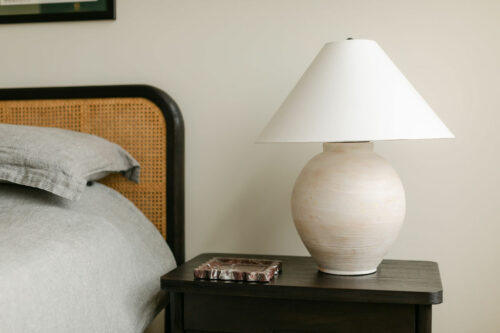 Modern lamp next to comfortable bed